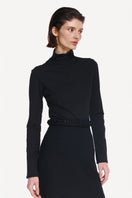 Black midi skirt by DELEGAN styled front view, showcasing its sleek design and length on a model.