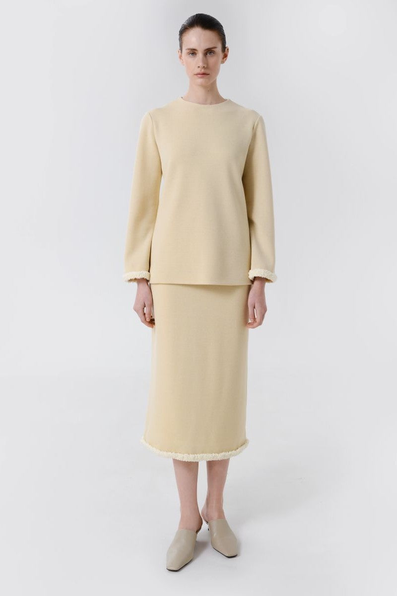 Delegen wool midi skirt styled with a front view, showcasing its textured fabric and elegant length for a sophisticated look.
