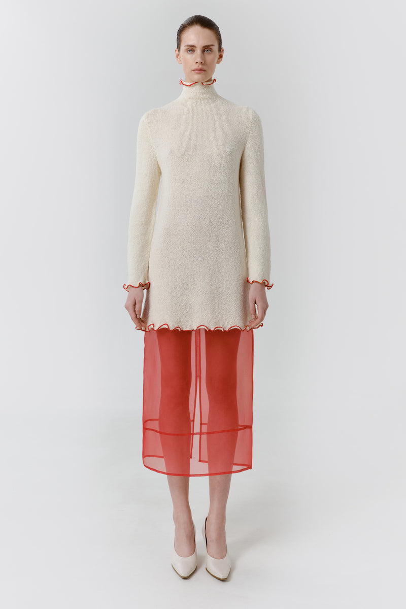Red veil midi skirt by DELEGAN, styled at the front showing flowy fabric and elegant design for fashionable wear.