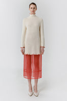 Red veil midi skirt by DELEGAN, styled at the front showing flowy fabric and elegant design for fashionable wear.