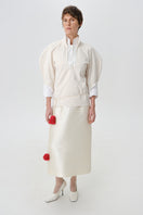DELEGAN velvet blush silk midi skirt styled at the front, showcasing soft fabric and elegant design.