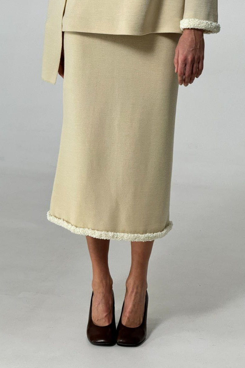Stylish front view of DELEGAN wool midi skirt with a fitted waist and flowing hem, perfect for fall fashion.
