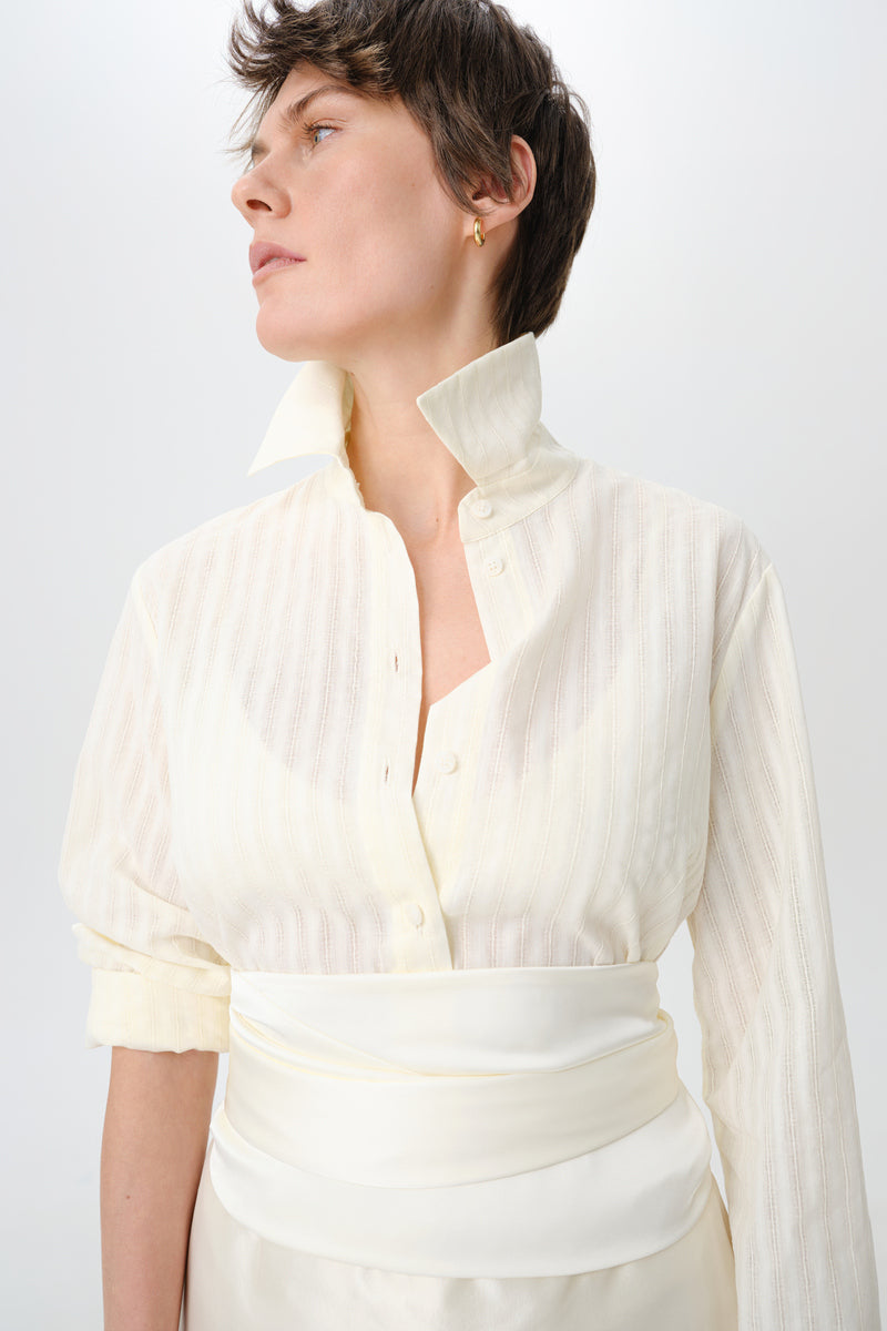 Delegan milk textured shirt displayed on a hanger, showcasing the front view with a modern, stylish design and soft fabric texture.