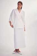 White midi skirt with knitted ornament by DELEGAN, styled front view showcasing the detailed knit design and elegant fit.
