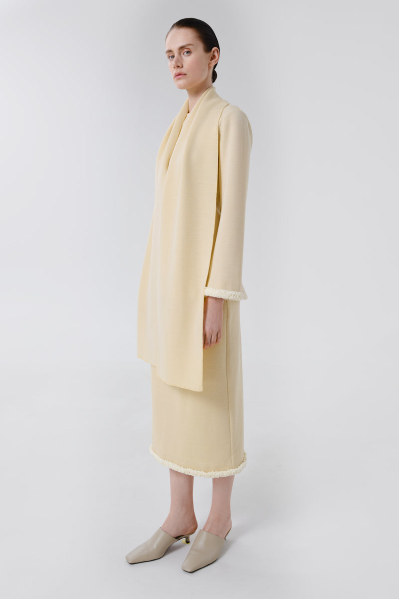Delegen wool midi skirt styled on a model, showcasing its elegant design and fabric texture against a neutral background.