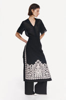 DELEGAN Plakhta filigree midi skirt styled with a side view, showcasing intricate lace details and a flowing silhouette.