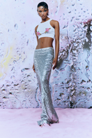 Pink cut-out top by Sudi Etuz featuring a handmade flower accessory, shown on a model with a stylish and trendy look.