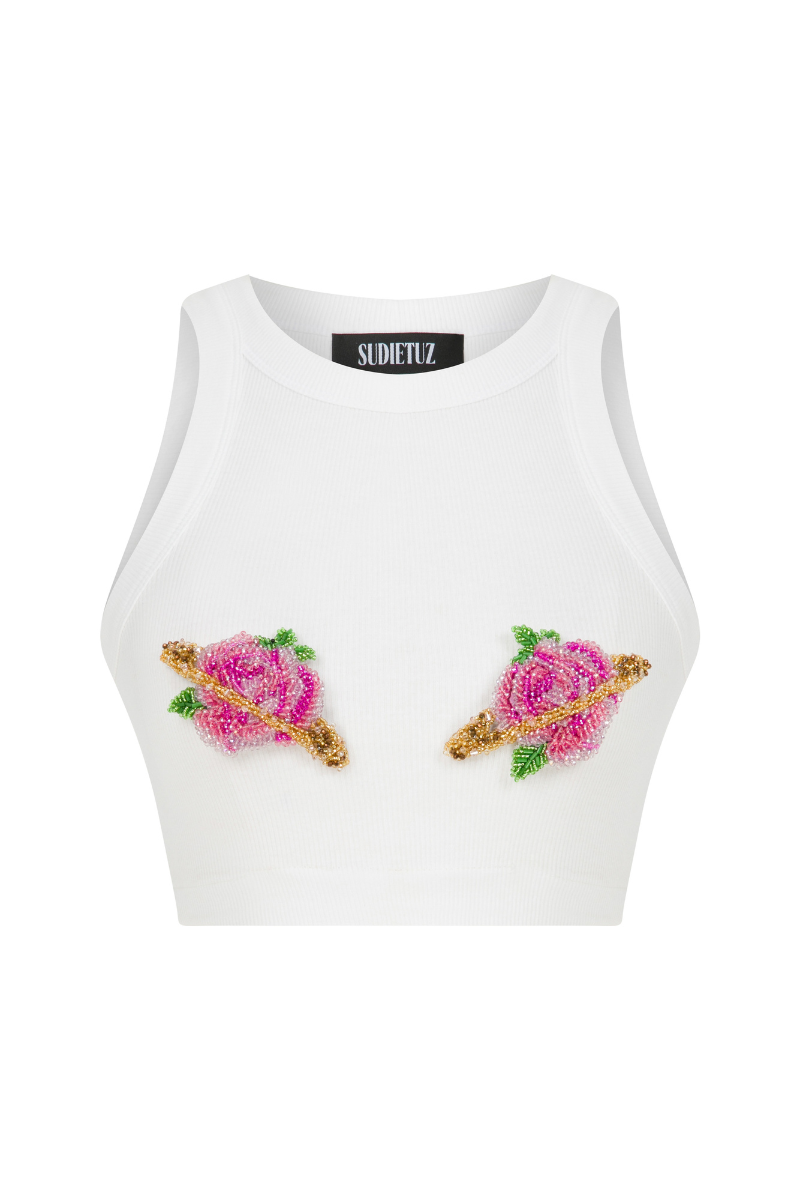Pink Sudi Etuz cut-out top with handmade flower accessory, featuring stylish design and vibrant color for trendy fashion.
