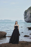 Black strapless gown by Tracy Studio featuring stone embellishments, full-length design, and a fitted silhouette.