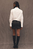 Denielle William St TT Studios denim mini skirt, light wash, fitted style, shown on a model.