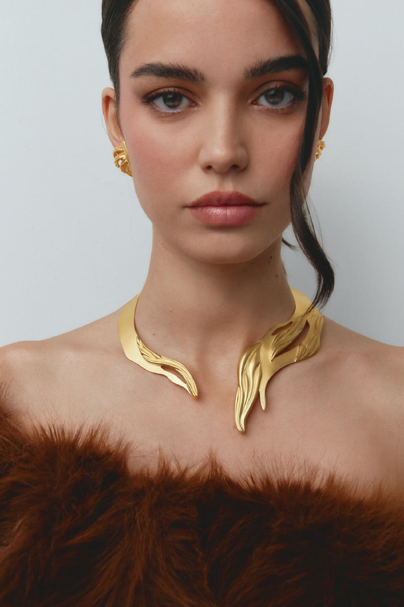 Gold earrings by Jude Benhalim featuring the UNA design, shown on a model with a stylish, minimalist look.
