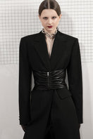 Black belted vegan leather coat by Vaska, showing front view with belt detail and classic coat silhouette in size XS.