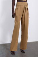SÉLONE VEYRA pleated trousers in warm camel, stylish pants with a tailored fit and pleated design, front view.