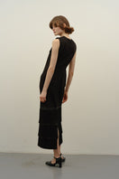 DELEGAN BAKHROMA black maxi dress shown from the back with long flowing fabric and elegant design.