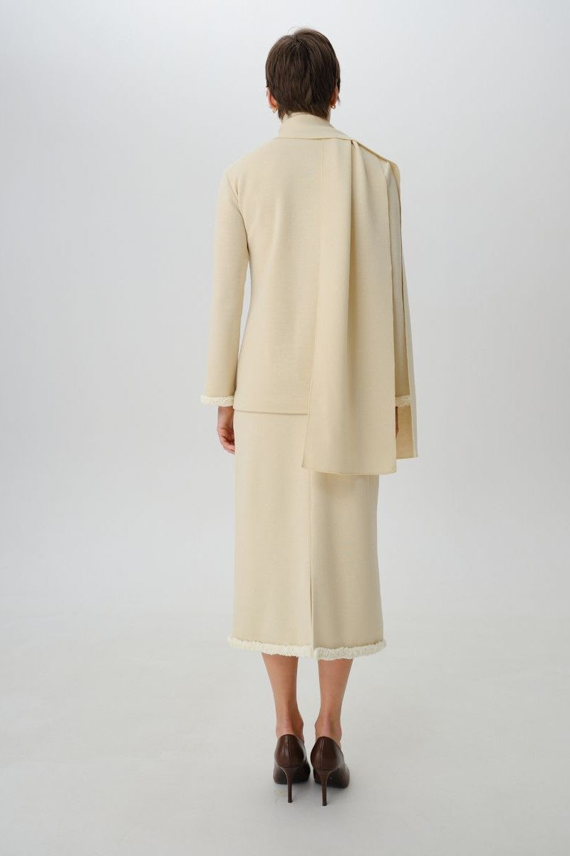 Wool midi skirt by DELEGAN, shown from the back, featuring a fitted waist and flowing A-line design in a textured fabric.