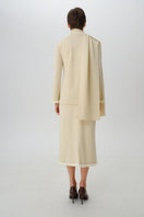 Wool midi skirt by DELEGAN, shown from the back, featuring a fitted waist and flowing A-line design in a textured fabric.