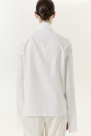 DELEGAN Still Line Shirt displayed from the back, featuring a modern, minimalist design with a relaxed fit and subtle detailing.