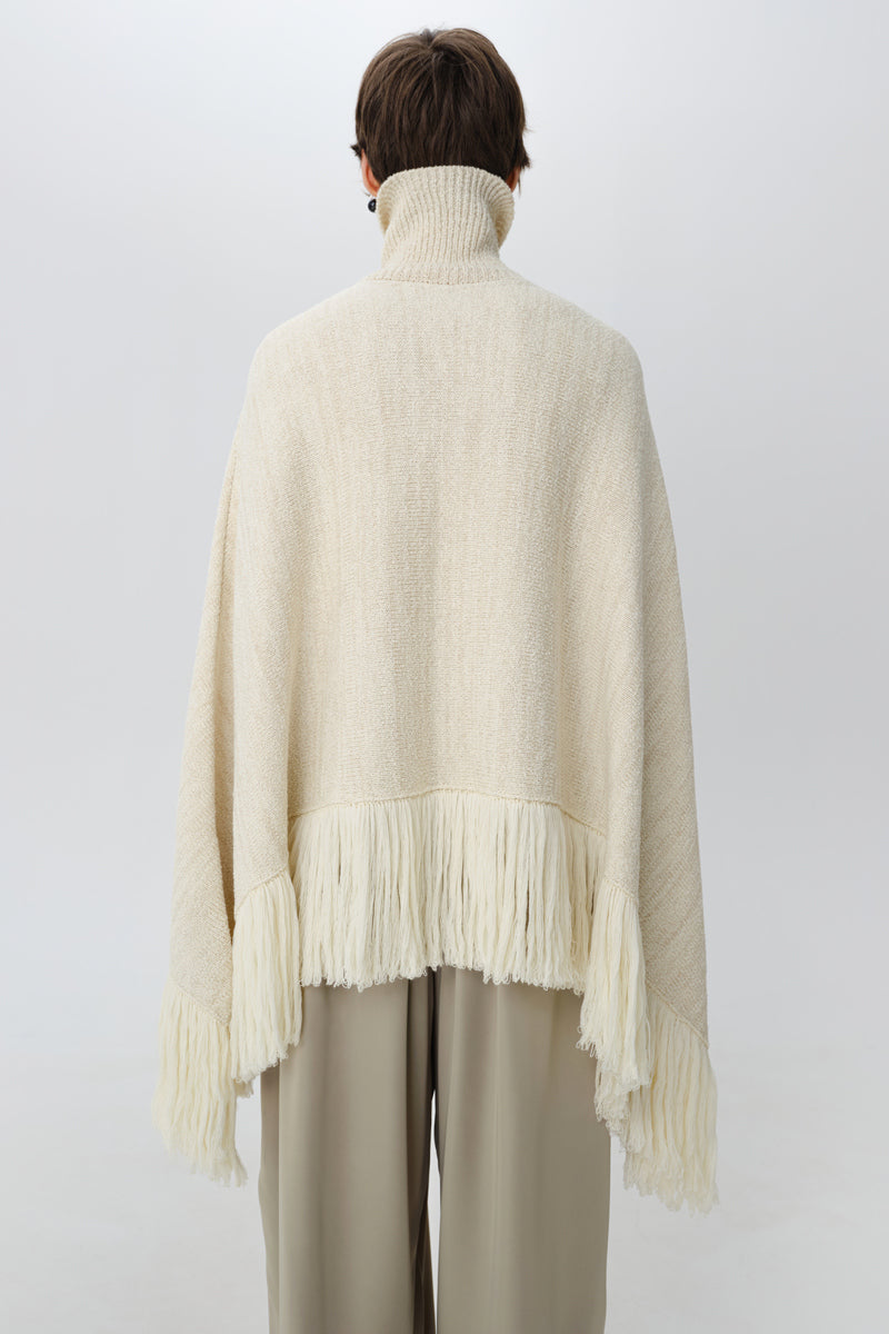 Delegen milk blush cardigan poncho displayed from the back showing its soft knit fabric and relaxed fit.