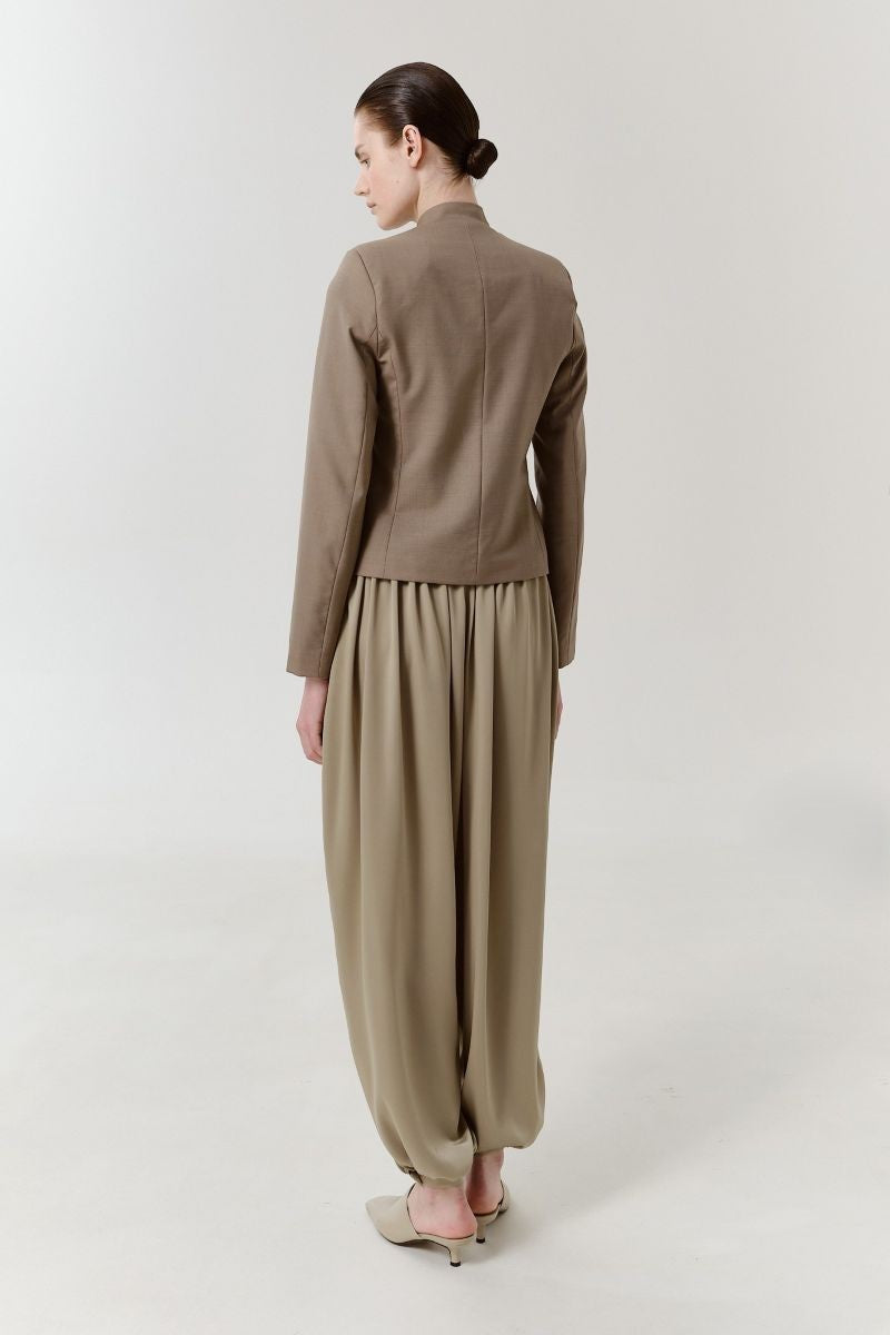 Back view of DELEGAN Olive Flow Pants showing relaxed fit, olive green fabric, and stylish design details.