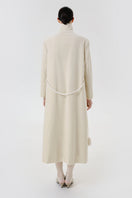 Back view of a stylish ivory velvet coat by Delegan, showcasing its smooth texture and elegant design.