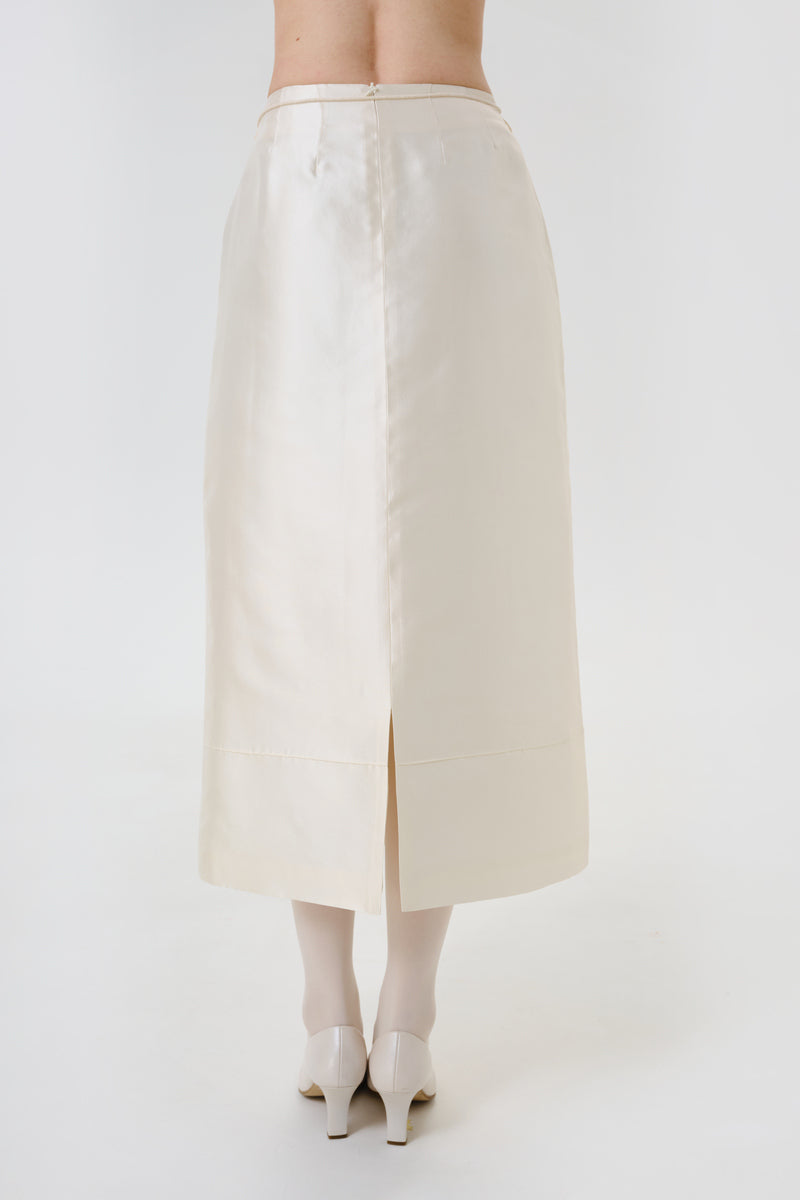 Back view of a DELEGAN velvet blush silk midi skirt showcasing smooth fabric and elegant drape on a model.