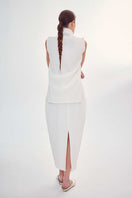 Back view of DELEGAN Milk cocoon midi skirt in soft fabric, showcasing its relaxed, flowing silhouette and elegant design.