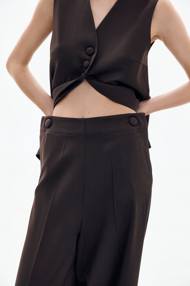 Close-up of DELEGAN architect brown trousers, showing the fabric texture and tailored fit on the pants.