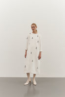 Ivory midi dress with white ornament details by DELEGAN, front view showcasing elegant design and flowing fabric.