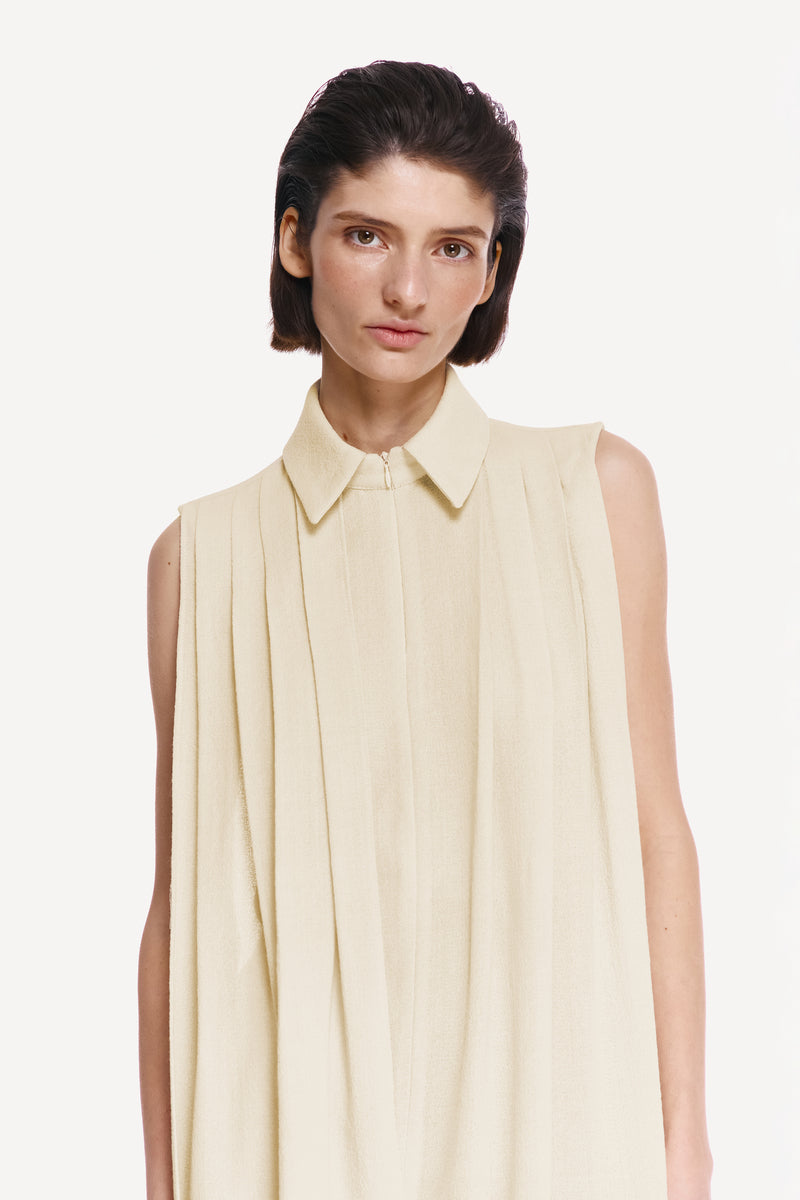 Warm ivory shirt scarf with silk fringe from DELEGAN, draped over a shirt, showcasing soft fabric and elegant fringe details.