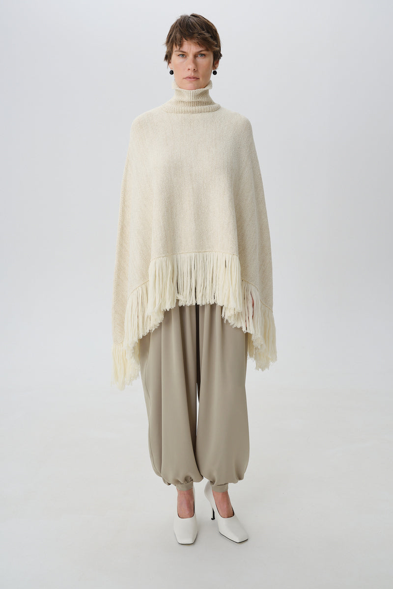 DELEGAN milk blush poncho cardigan worn front view, soft fabric with blush pink color, cozy and stylish for casual wear