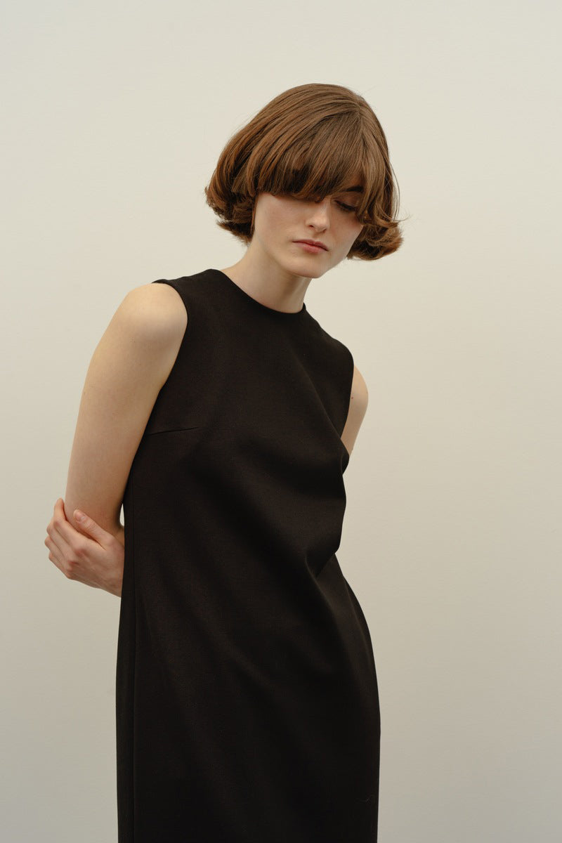 Black BAKHROMA midi dress by DELEGAN, featuring a fitted bodice and flowing skirt, shown worn front view.