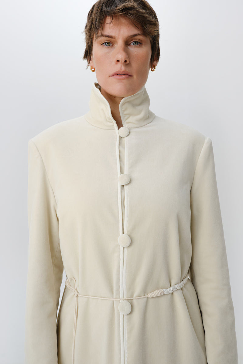 Ivory velvet coat by Delegan displayed on a model, showing the front view with a stylish collar and tailored fit.