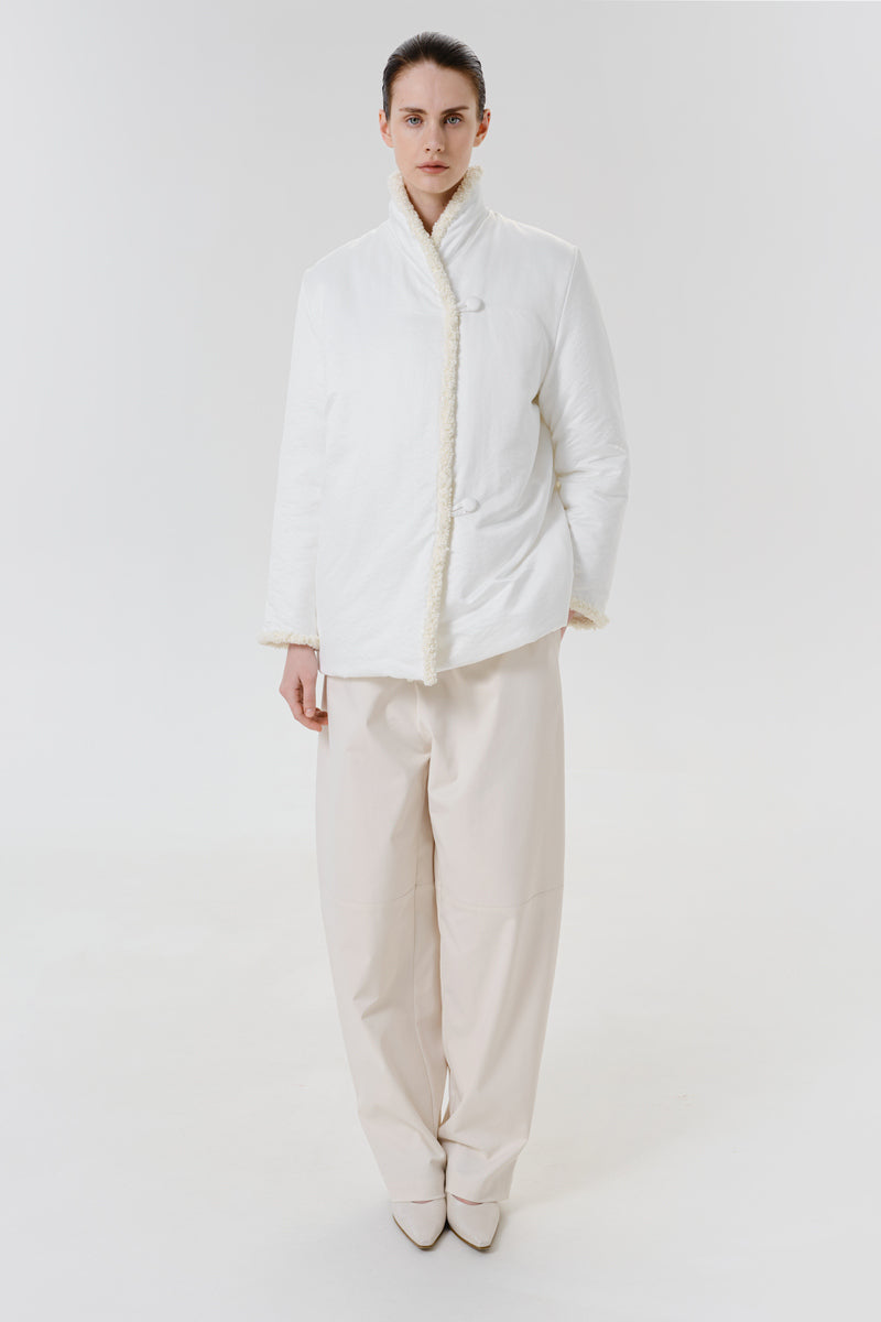 White DELEGAN jacket worn front view showing lightweight fabric and casual style, with a zipper and collar detail.