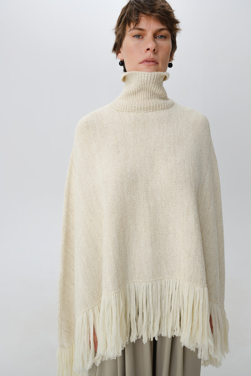 DELEGAN Milk Blush Poncho cardigan worn front view, soft fabric, relaxed fit, stylish and cozy women's outerwear.