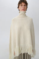 DELEGAN Milk Blush Poncho cardigan worn front view, soft knit fabric with relaxed fit and stylish design.