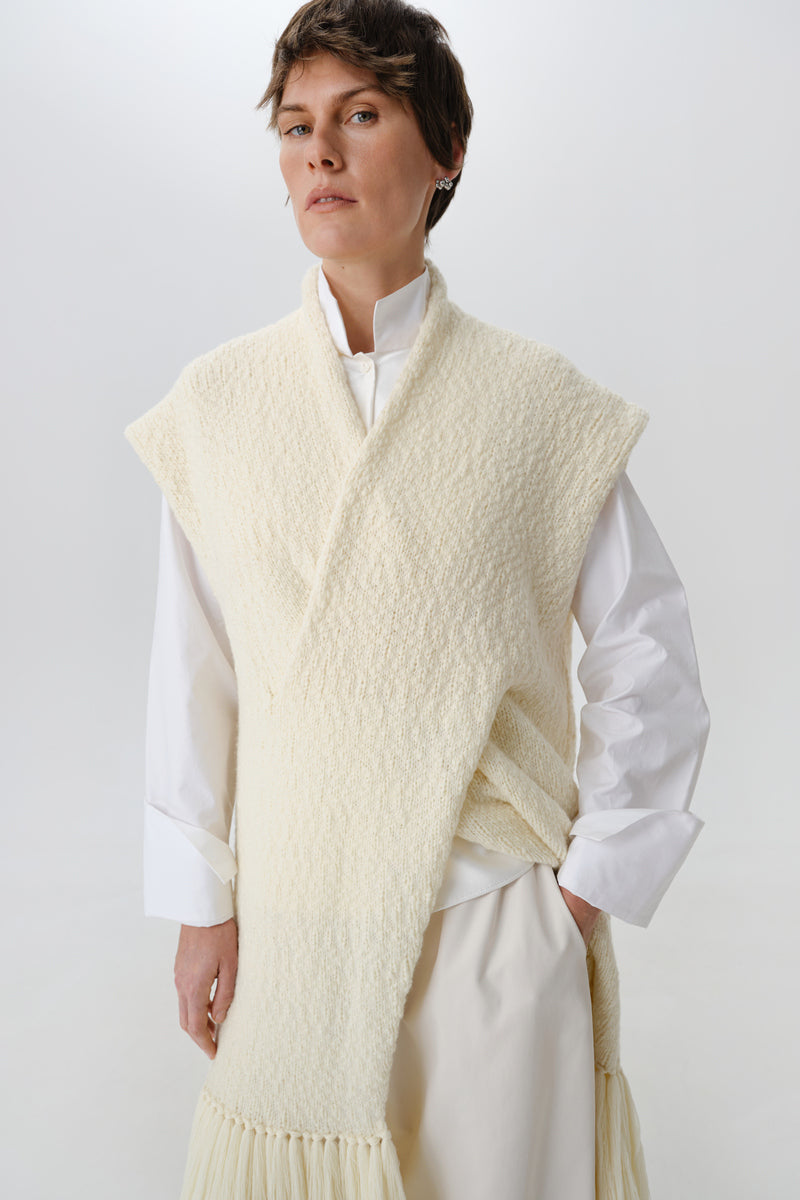 Textured knit cardigan vest from DELEGAN worn front view, showcasing the soft, patterned fabric and classic V-neck design.
