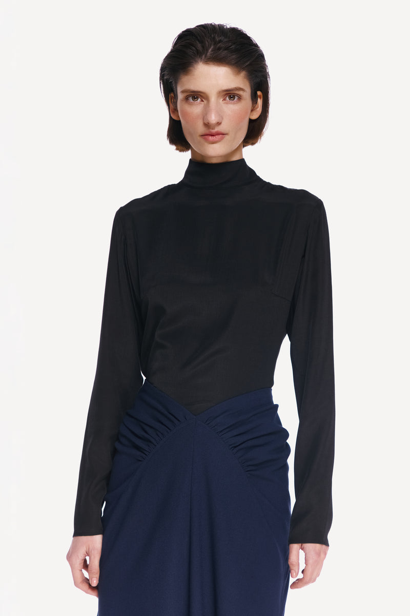 Black tie neck blouse by Delegan, front view showing sleek fabric, classic collar, and elegant design for stylish shirts.