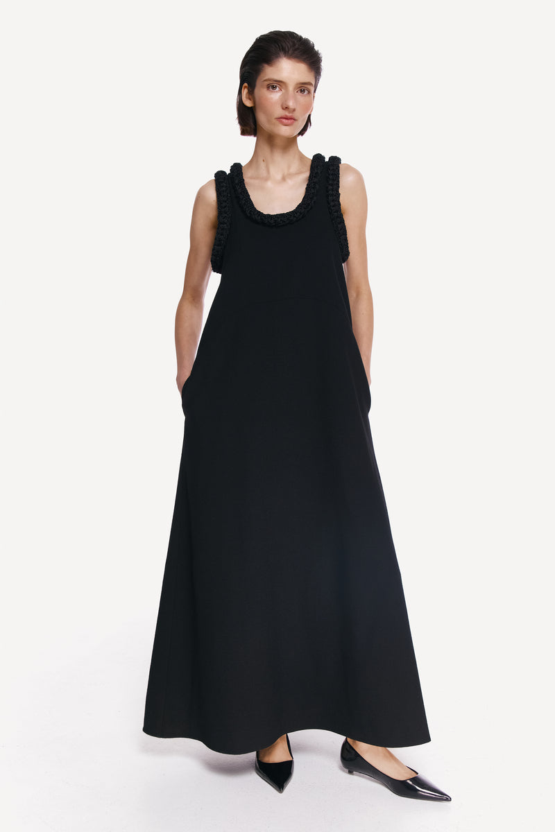 DELEGAN KOSSA Maxi Dress shown front view, flowing fabric, sleeveless design, elegant style, worn by a model.