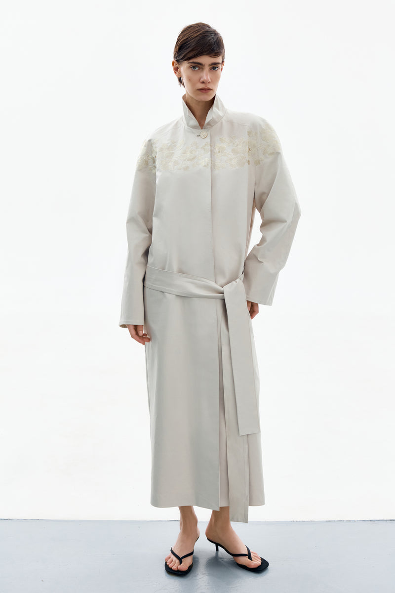 Petal grey beige trench coat by DELEGAN, shown worn front view, stylish and lightweight outerwear for transitional weather.