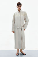 Petal grey beige trench coat by DELEGAN, front view showing classic collar, button closure, and stylish fit.
