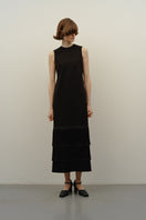 DELEGAN BAKHROMA black maxi dress displayed on a model, featuring a flowing silhouette and elegant design.