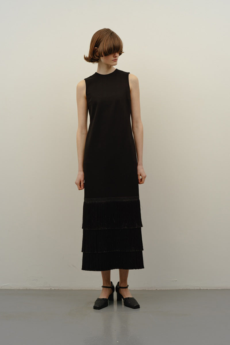 DELEGAN BAKHROMA black maxi dress displayed on a model, featuring a flowing silhouette and elegant design.