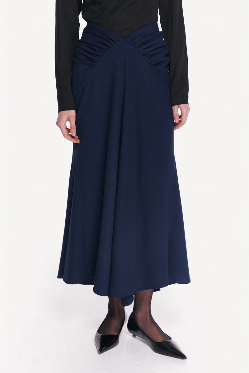 Midnight blue DELEGAN midi skirt displayed from the front, showing its sleek, flowing fabric and stylish length.
