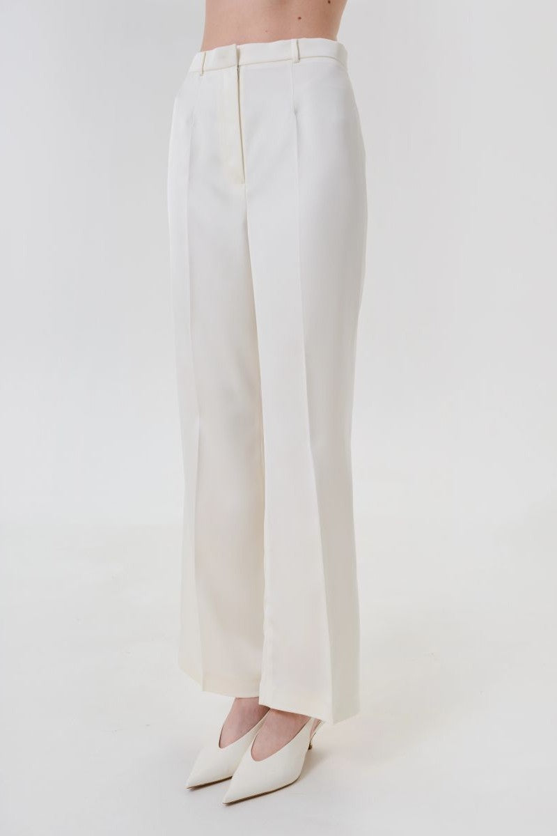 Ivory satin pants with belt by DELEGAN, front view showing smooth fabric and stylish waist detail.