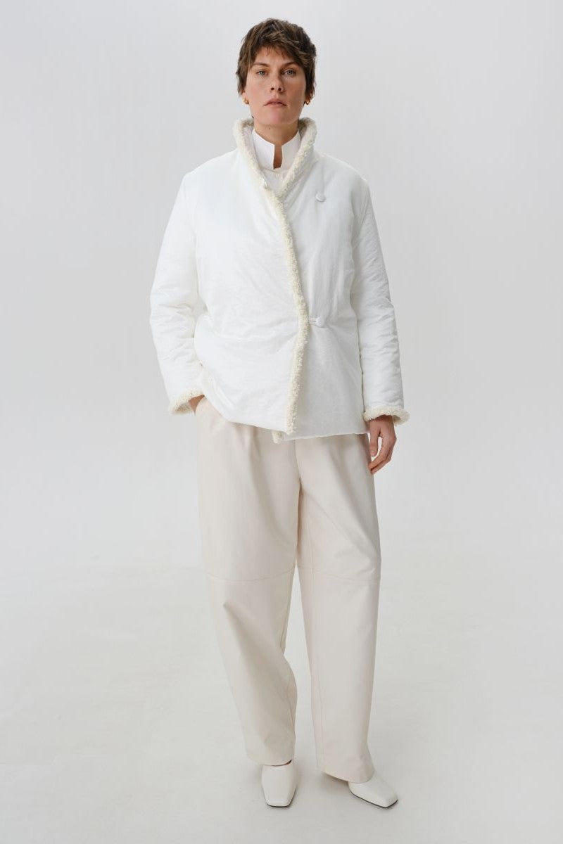 White DELEGAN jacket shown from the front, featuring a stylish and sleek design with a zip-up closure and modern fit.