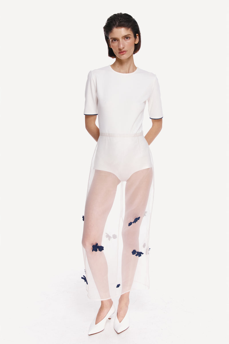 White short sleeve bodysuit by Delegan, front view showing fitted design and simple neckline, casual top for everyday wear.