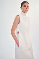 Worn side view of the DELEGAN Structural Top in milk, featuring a stylish, fitted design made from comfortable fabric.