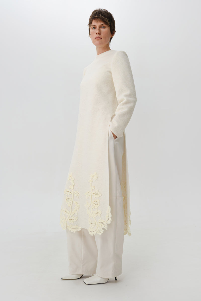 Worn side view of DELEGAN statement wool midi dress, showcasing its stylish fit and textured fabric.