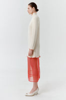 Red blush midi dress by Delegan shown from the side, featuring a fitted bodice and flowing skirt.