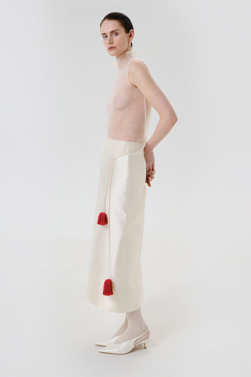 Side view of a DELEGAN velvet blush silk midi skirt featuring a smooth, flowing fabric and elegant silhouette.